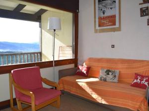 a room with a bed and a chair and a window at Appartement Font-Romeu-Odeillo-Via, 2 pièces, 7 personnes - FR-1-580-27 in Font-Romeu-Odeillo-Via