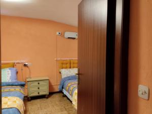 Habitación con 2 camas individuales y puerta en Casetta del borgo, en Montelaterone