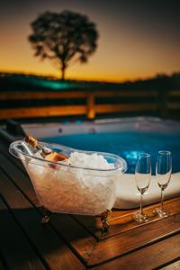 a bowl of ice cream and two wine glasses on a table at Pousada Capanna del Vale - Vale dos Vinhedos in Bento Gonçalves