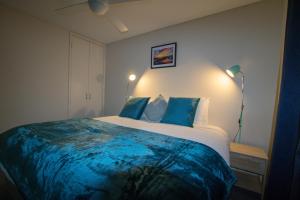 um quarto com uma cama grande e lençóis azuis em Retreat on Fearn em Margaret River Town
