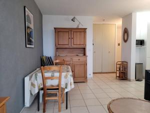 uma cozinha com uma mesa com cadeiras e um armário em Appartement Bormes-les-Mimosas, 3 pièces, 4 personnes - FR-1-610-73 em Bormes-les-Mimosas