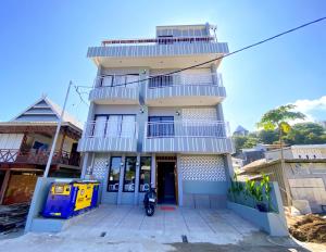 Un edificio con una motocicleta estacionada enfrente. en Flamingo Ceria, en Labuan Bajo