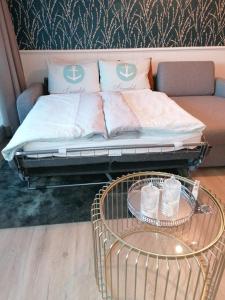 Bett in einem Zimmer mit einem Tisch und einem Sofa in der Unterkunft Apartment 509 - FeWo in der Villa Kurpark in Zingst