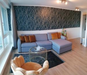 ein Wohnzimmer mit einem Sofa und einem Tisch in der Unterkunft Apartment 509 - FeWo in der Villa Kurpark in Zingst