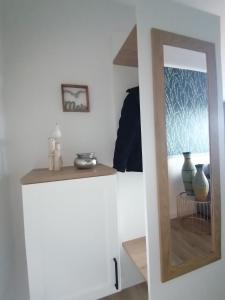 einen weißen Schrank mit einem Spiegel im Zimmer in der Unterkunft Apartment 509 - FeWo in der Villa Kurpark in Zingst