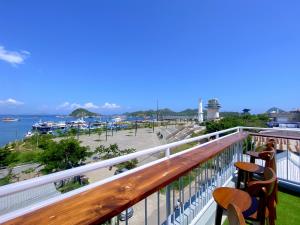 balcón con 2 sillas y vistas al puerto deportivo en Flamingo Ceria, en Labuan Bajo