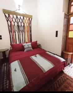1 dormitorio con 1 cama con cabecero de madera en Dar Bryan, en Fez