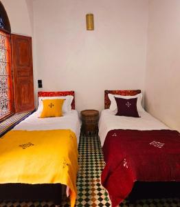 two beds sitting next to each other in a room at Dar Bryan in Fès