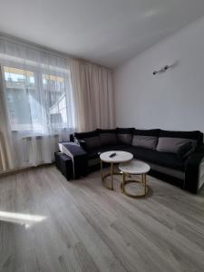 - un salon avec un canapé noir et une table dans l'établissement Apartament Korzenioskiego 7/2, à Przemyśl