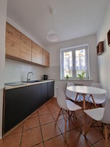 - une cuisine avec une table, des chaises et un évier dans l'établissement Apartament Korzenioskiego 7/2, à Przemyśl