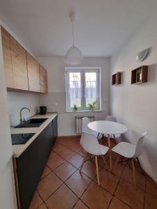 une petite cuisine avec une table et des chaises. dans l'établissement Apartament Korzenioskiego 7/2, à Przemyśl