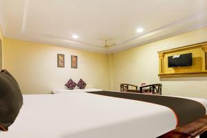 a bedroom with a bed and a tv on the wall at Super Collection O Hotel Adithya Central in Elūru