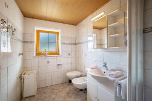 biała łazienka z umywalką i toaletą w obiekcie Gartnerhof Apt Glücksklee w mieście Fleres