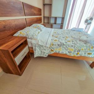 1 dormitorio con 1 cama con cabecero de madera en Hotel Costa Sur, en Camaná