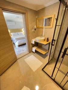 a bathroom with a mirror and a sink and a bed at Dalaman Airport AliBaba House in Dalaman