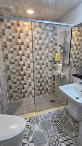 y baño con ducha, aseo y lavamanos. en Parkcliffe, en Jeju