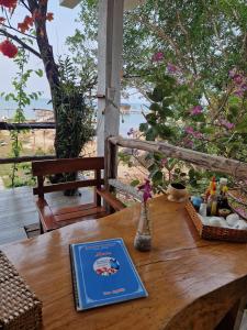 una mesa de madera con un libro encima en Butterfly Rose Beach Resort Phú Quốc Francophone en Phu Quoc