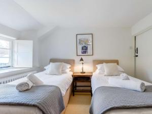 Duas camas individuais num quarto com uma mesa em 2 Bed in Dulverton 47152 em East Anstey