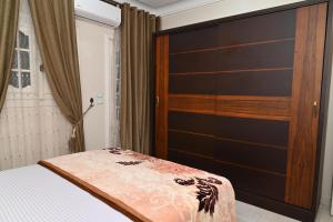 a bedroom with a bed with a large wooden headboard at وادى الملوك للشقق الفندقية in Mansoura