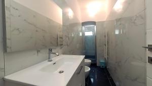 a white bathroom with a sink and a toilet at Tra centro e mare - Intero appartamento con parcheggio in Savona +10 photos