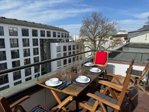 balcón con mesa de madera y sillas en Art Apartments, en Hamburgo