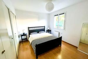 een slaapkamer met een bed in een witte kamer bij Sun and comfort near the park in Les Angles Gard