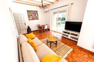 een woonkamer met een bank en een televisie bij Sun and comfort near the park in Les Angles Gard