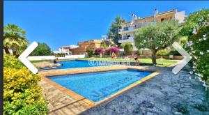 a large swimming pool in front of a building at Las mejores puestas de sol in Roses