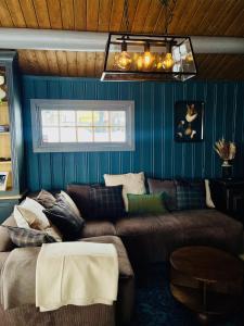 a living room with a couch and blue walls at Cosy and Quiet Cabin with Sauna close to Hemsedal in Lykkja