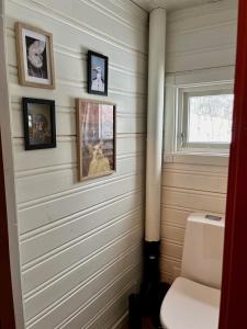 a bathroom with pictures on the wall and a toilet at Cosy and Quiet Cabin with Sauna close to Hemsedal in Lykkja