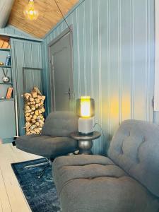 a living room with two chairs and a table with a lamp at Cosy and Quiet Cabin with Sauna close to Hemsedal in Lykkja