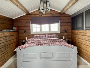 sypialnia z białym łóżkiem w pokoju z drewnianymi ścianami w obiekcie Cosy and Quiet Cabin with Sauna close to Hemsedal w mieście Lykkja