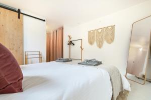 a bedroom with a white bed and a mirror at Retraite Bohème - Projecteur, Netflix, Lac Proche in Estavayer-le-Lac