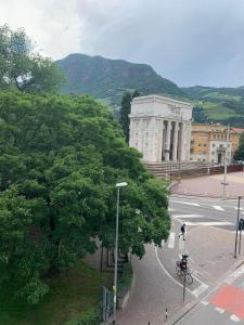 una persona que conduce una motocicleta en una calle frente a un edificio en Alps Apartments Viktory, en Bolzano