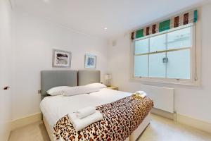 - une chambre dotée d'un lit avec une couverture à motifs léopards dans l'établissement Stunning 2BD flat in South Kensington with a patio, à Londres
