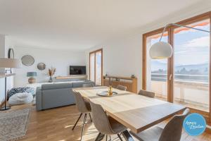 ein Wohnzimmer mit einem Tisch und einem Sofa in der Unterkunft L'Éclat D'annecy - Appartement Avec Vue Lac in Annecy