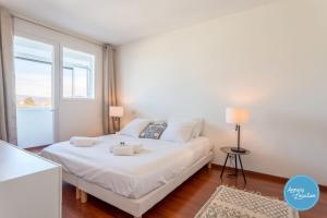 Schlafzimmer mit einem großen weißen Bett und einem Fenster in der Unterkunft L'Éclat D'annecy - Appartement Avec Vue Lac in Annecy