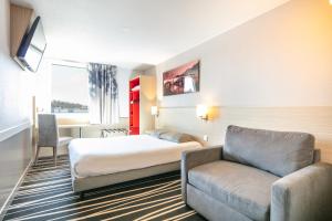 une chambre d'hôtel avec un lit et un canapé dans l'établissement B&B HOTEL Lyon Aéroport Saint-Quentin-Fallavier, à Saint-Quentin-Fallavier