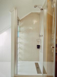 y baño con ducha y puerta de cristal. en O Encanto da Vila en Vila Real de Santo António