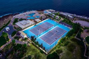 een uitzicht op een tennisbaan naast de oceaan bij Radisson Blu Resort, Malta St. Julian's in St Julian's