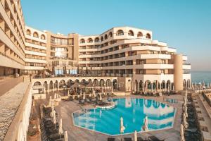 ein Hotel mit einem Pool vor einem Gebäude in der Unterkunft Radisson Blu Resort, Malta St. Julian's in St Julian's