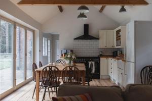 a kitchen and dining room with a table and chairs at Bears Cottage in Wood Norton