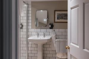 ein Badezimmer mit Waschbecken und Spiegel in der Unterkunft Bears Cottage in Wood Norton + 18 Fotos