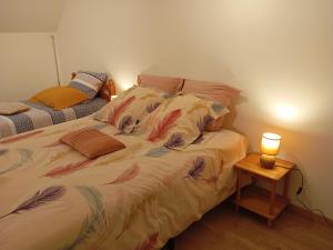 a bedroom with a bed with a lamp on a table at Charmant Gîte Familial à Saint-Benoît-sur-Loire - 2 Chambres, Parking, Proche Patrimoine et Nature - FR-1-590-426 in Saint-Benoît-sur-Loire