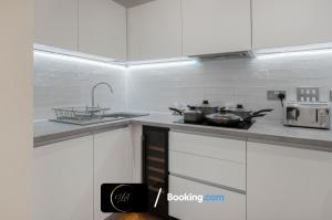 a kitchen with a counter top with pots and pans at Stylish City Centre Stay, Serviced Apartment in Birmingham Suitable For Families & Contractors, Wi-Fi & Netflix - By Noor Luxury Accommodations in Birmingham