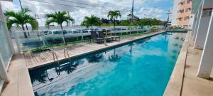 einem großen Pool mit Palmen und einem Flugzeug in der Unterkunft COPIA0102 - Condomínio Cores de Piatã in Salvador