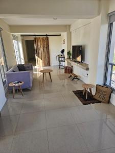 sala de estar con sofá púrpura y mesas en Apartamentos Centricos en Mendoza