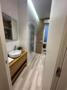 a white bathroom with a sink and a mirror at Cosy Apt 4P-porte maillot -palais des congrés in Paris