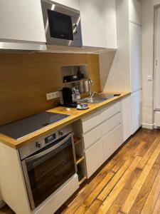 a small kitchen with a sink and a stove at Cosy Apt 4P-porte maillot -palais des congrés in Paris