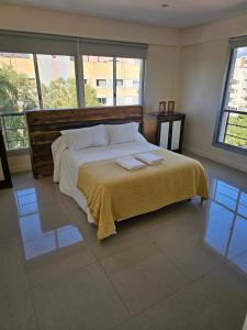a bedroom with a large bed with two towels on it at Apartamentos Centricos in Mendoza